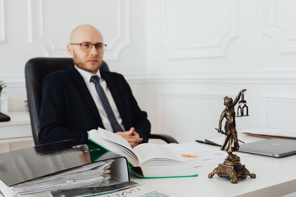 Rendez-vous avec un avocat : avocat dans son bureau avec des documents juridiques